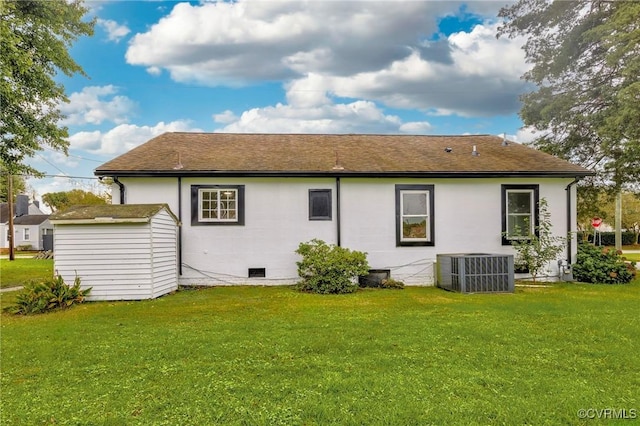 back of property with a storage shed, central AC, a lawn, and an outdoor structure