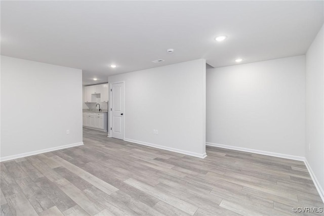 interior space featuring light wood-style flooring, baseboards, and recessed lighting