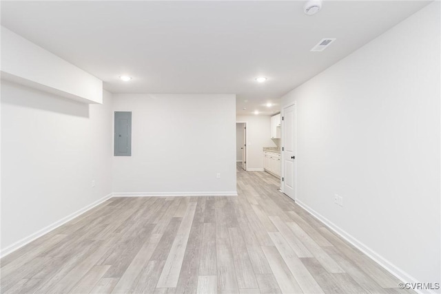 unfurnished room with recessed lighting, visible vents, light wood-type flooring, electric panel, and baseboards