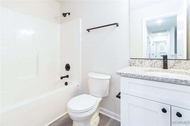 full bathroom featuring bathtub / shower combination, toilet, vanity, wood finished floors, and baseboards