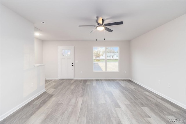 unfurnished living room with light wood-style flooring, baseboards, and ceiling fan