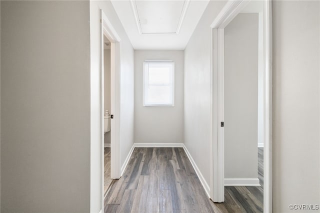 corridor with wood finished floors and baseboards