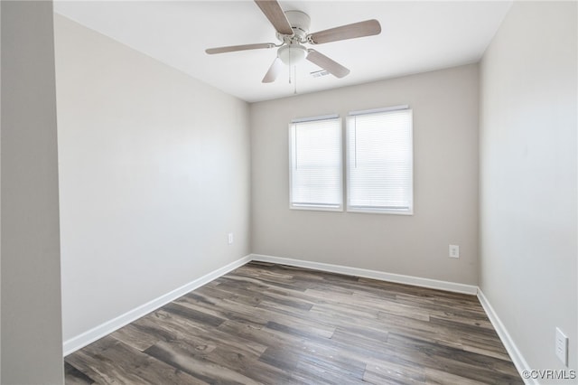 spare room with ceiling fan, dark wood-type flooring, and baseboards