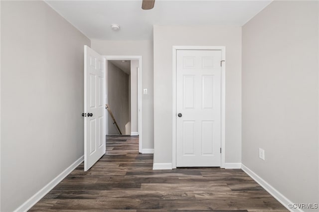 unfurnished room with dark wood-style floors and baseboards