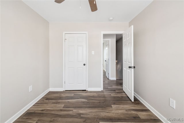 unfurnished bedroom with dark wood finished floors, a ceiling fan, and baseboards