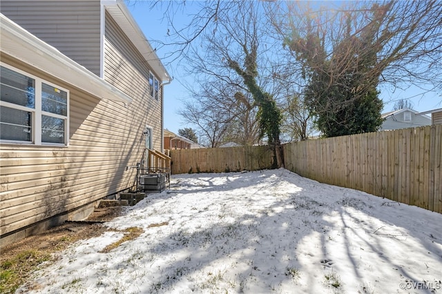 yard covered in snow featuring a fenced backyard