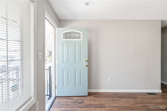 foyer featuring dark wood-style flooring and baseboards