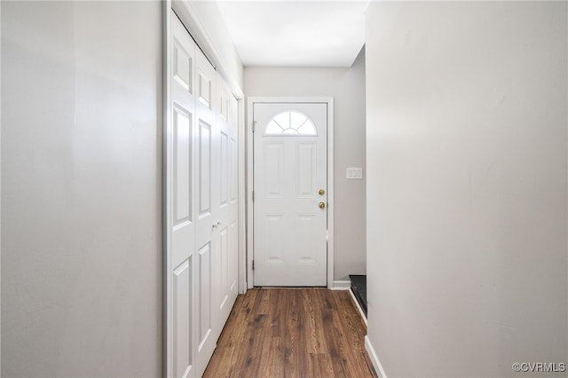 doorway to outside featuring dark wood-type flooring and baseboards