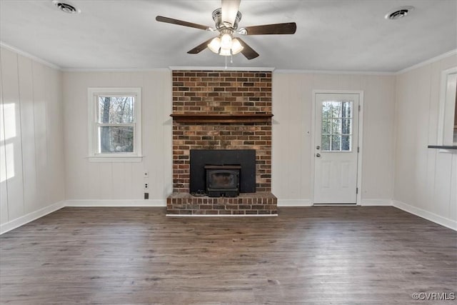 unfurnished living room featuring ornamental molding, dark wood-style flooring, visible vents, and a healthy amount of sunlight
