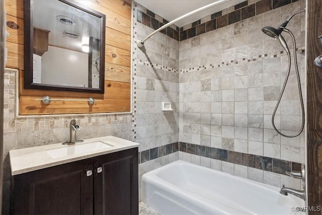 full bath featuring tile walls, bathtub / shower combination, vanity, and decorative backsplash