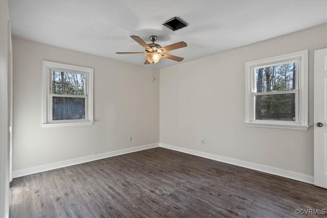 empty room featuring a ceiling fan, dark wood finished floors, and baseboards