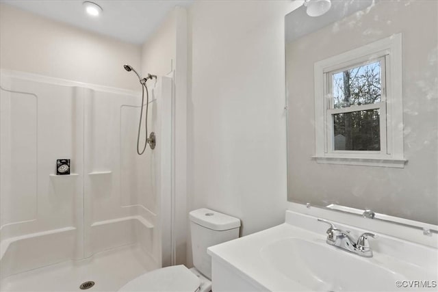 bathroom with toilet, a shower stall, and vanity