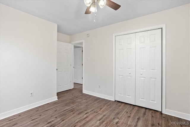unfurnished bedroom featuring ceiling fan, a closet, baseboards, and wood finished floors