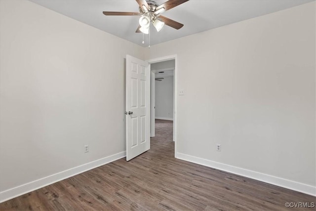 unfurnished room with dark wood finished floors, baseboards, and ceiling fan