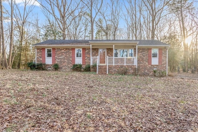 ranch-style home with covered porch, brick siding, and crawl space