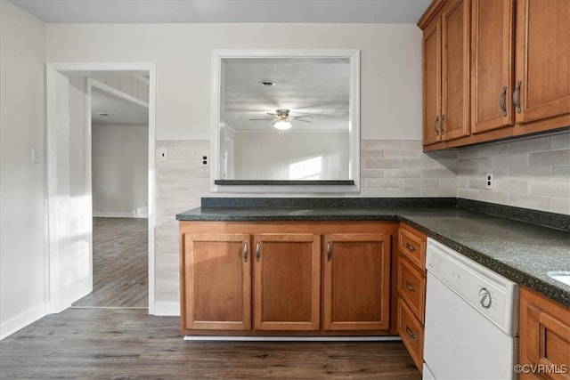 kitchen with dark wood-style floors, dark countertops, brown cabinetry, and white dishwasher