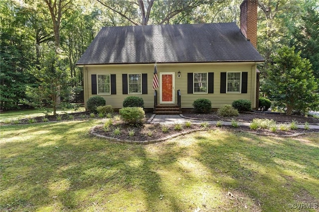 view of front of house featuring entry steps, a shingled roof, a chimney, and a front yard