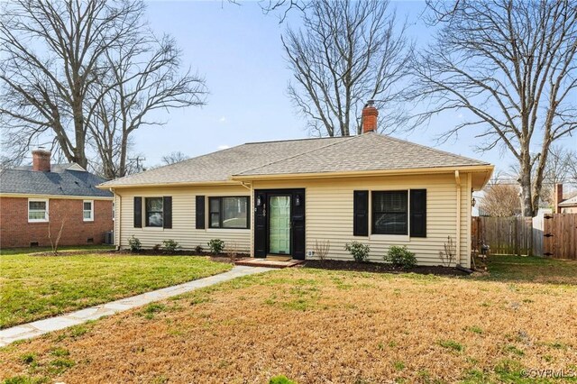 ranch-style home with roof with shingles, a chimney, a front yard, and fence