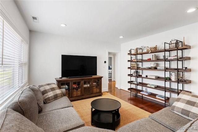 living area with baseboards, visible vents, wood finished floors, and recessed lighting