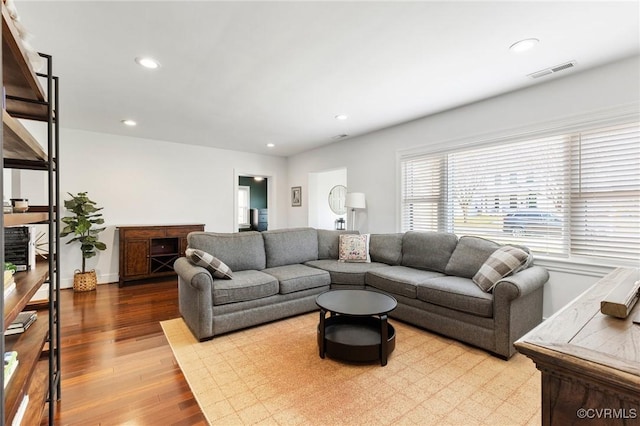 living area featuring baseboards, visible vents, wood finished floors, and recessed lighting