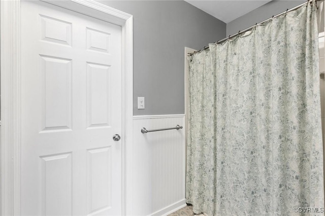 full bath with a wainscoted wall