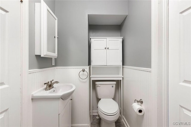 bathroom featuring wainscoting, vanity, and toilet