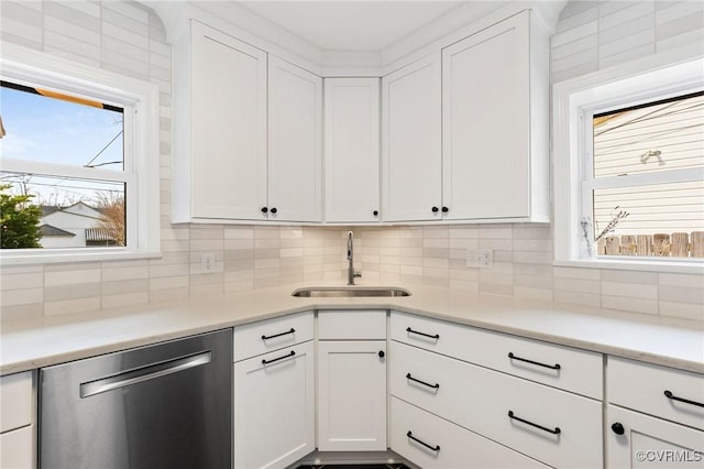 kitchen with plenty of natural light, white cabinets, dishwasher, and a sink