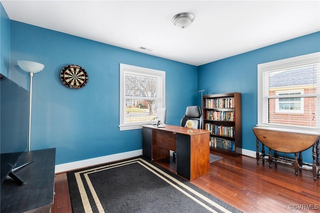 office area with visible vents, baseboards, and wood finished floors