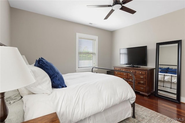 bedroom with visible vents, dark wood finished floors, and a ceiling fan