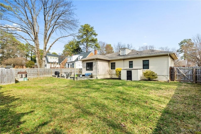 back of property with a lawn and a fenced backyard