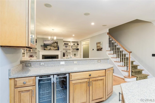 kitchen featuring light stone counters, wine cooler, recessed lighting, ornamental molding, and open floor plan