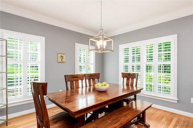 dining area with baseboards, light wood finished floors, a wealth of natural light, and crown molding