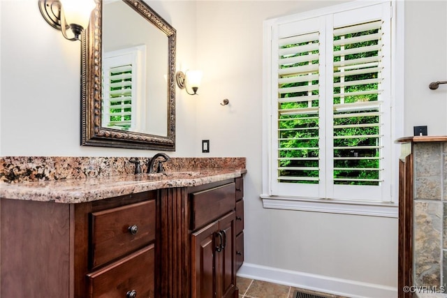 bathroom featuring vanity, baseboards, and tile patterned floors