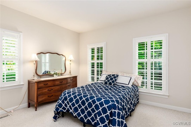 carpeted bedroom with visible vents and baseboards