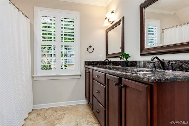 full bathroom featuring baseboards, double vanity, a sink, and crown molding