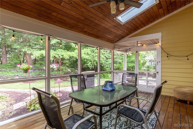 sunroom / solarium featuring wooden ceiling, lofted ceiling with skylight, and a ceiling fan