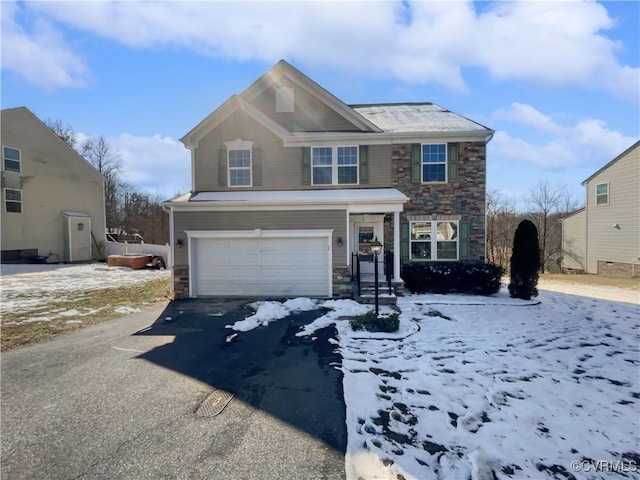 view of front of property featuring driveway, stone siding, and a garage