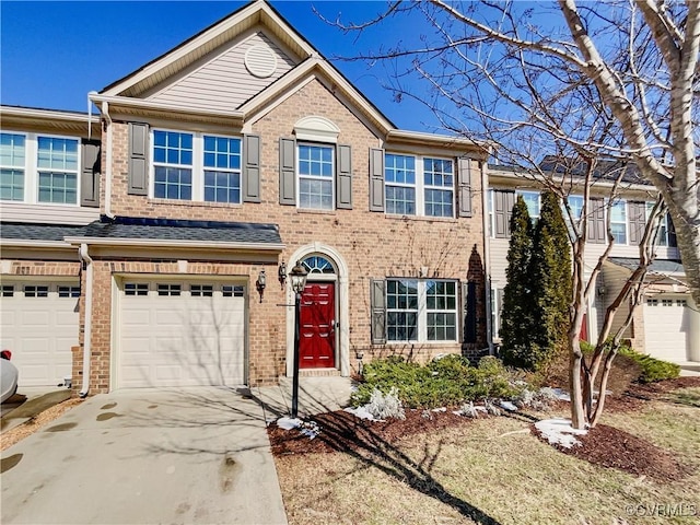 view of property featuring a garage, concrete driveway, and brick siding