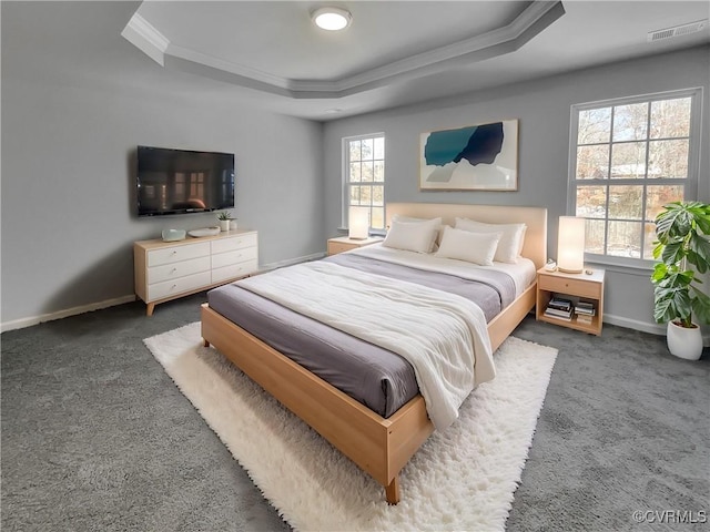 bedroom with visible vents, baseboards, a raised ceiling, and dark colored carpet