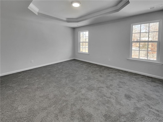 unfurnished room with dark carpet, visible vents, baseboards, and a raised ceiling