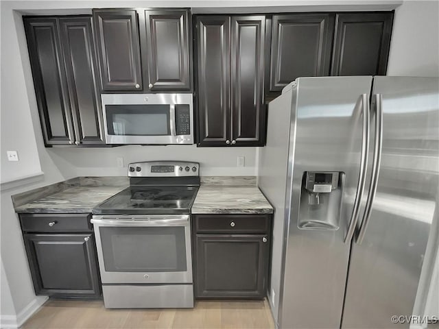 kitchen featuring appliances with stainless steel finishes, light countertops, and light wood-style flooring