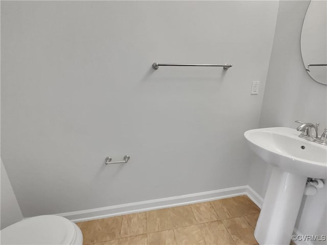 bathroom featuring toilet and baseboards