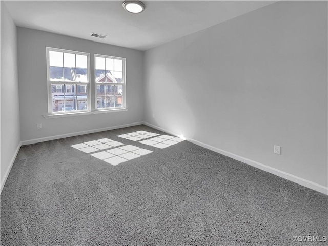 spare room with carpet, visible vents, and baseboards