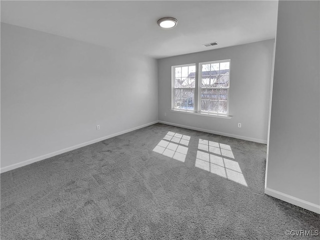 carpeted spare room featuring visible vents and baseboards