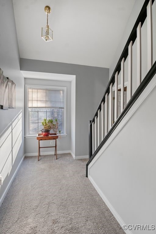 foyer with stairway, carpet, and baseboards