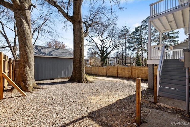 view of yard featuring a deck, stairway, an outdoor structure, and a fenced backyard