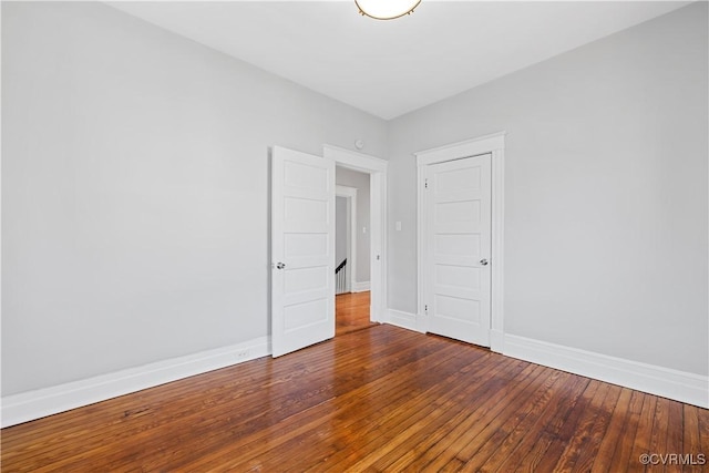 spare room featuring hardwood / wood-style flooring and baseboards