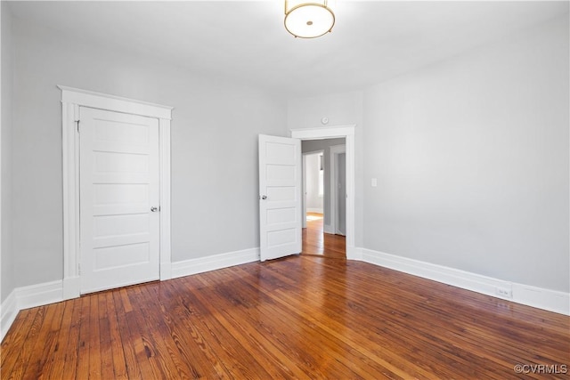 unfurnished bedroom with hardwood / wood-style flooring and baseboards