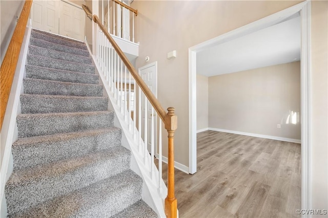 stairway featuring wood finished floors and baseboards