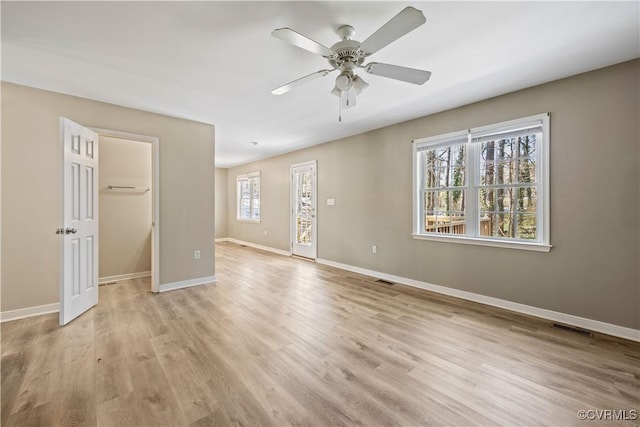 spare room featuring light wood-style flooring, visible vents, baseboards, and a ceiling fan